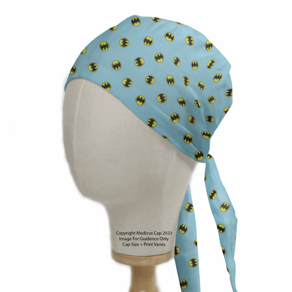 A mannequin head displays the Medicus Scrub Caps Batman Signal On Blue Scrub Cap featuring iconic black and yellow bat symbols.