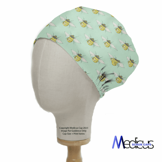 A mannequin showcases the vibrant Bees On Teal Scrub Cap by Medicus, featuring a playful bee pattern and the companys logo at the bottom right—ideal for healthcare professionals who appreciate style and sustainability.