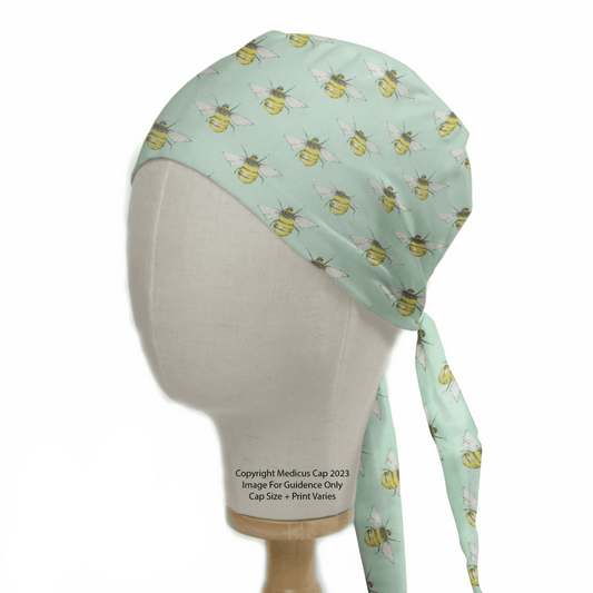 A mannequin head displays the Bees On Teal Scrub Cap by Medicus Scrub Caps, designed for healthcare professionals and featuring adjustable back ties as a sustainable choice.