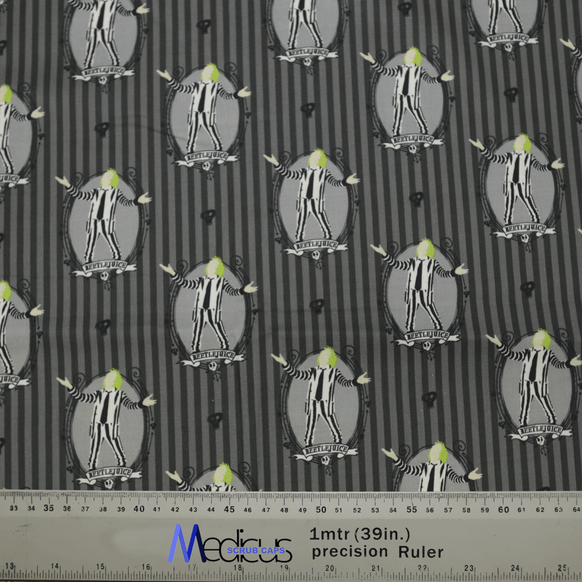 The Medicus Scrub Caps Beetlejuice Scrub Cap showcases a whimsical striped pattern featuring cartoon penguins in tuxedos on a black background. Their bright green eyes add charm, with the design repeating uniformly and a 39-inch ruler at the bottom of the image.