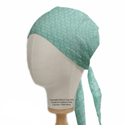 On a mannequin head, the Medicus Scrub Caps Best Vet Tech Scrub Cap in teal features BEST VET TECH EVR text pattern. This eco-friendly cap offers a perfect fit with ties at the back.