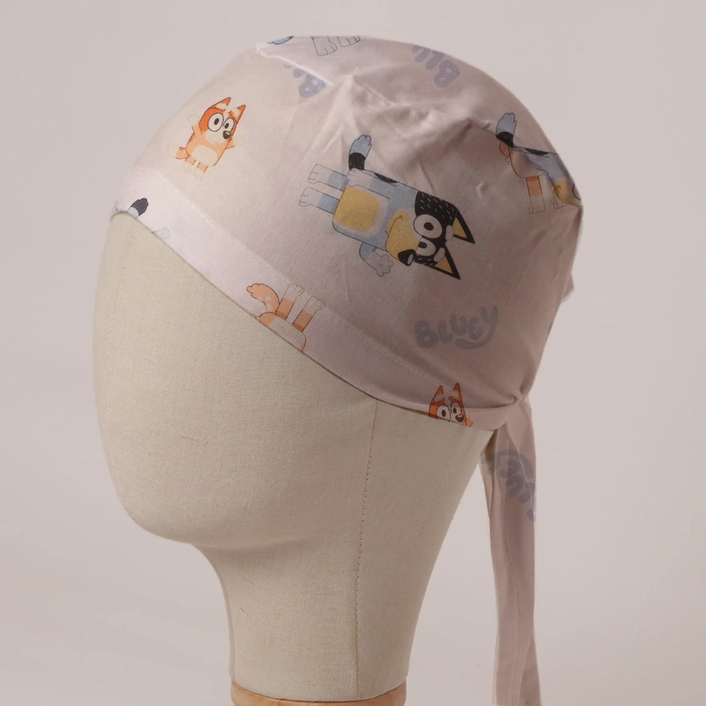 Bluey and Bingo Tossed on White fabric scrub cap in Bandana tie-back style: Bluey and Bingo tossed on white