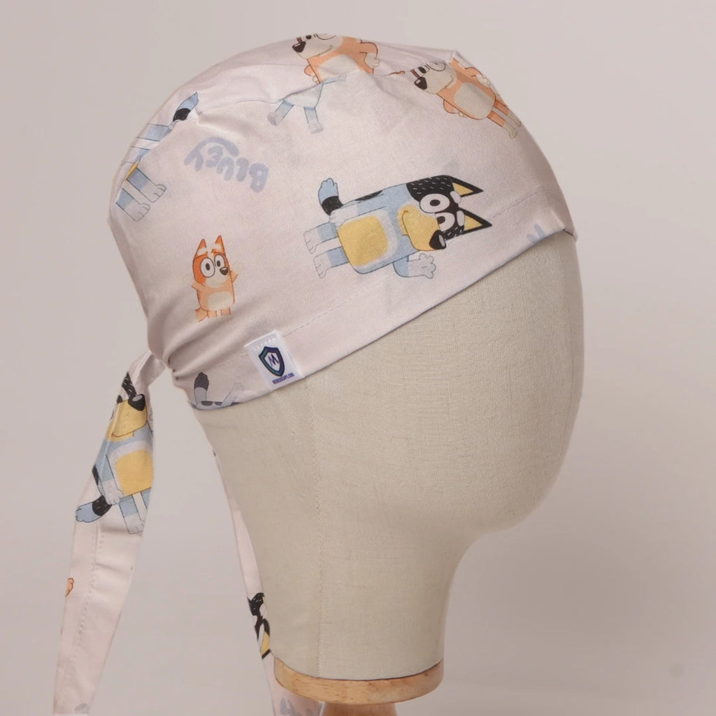 Bluey and Bingo Tossed on White fabric scrub cap in Bandana tie-back style on mannequin head, front right view with the