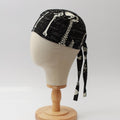 Mannequin head wearing Medicus Scrub Cap with skeleton-themed print, glow-in-the-dark, on a wooden stand against a white backdrop.
