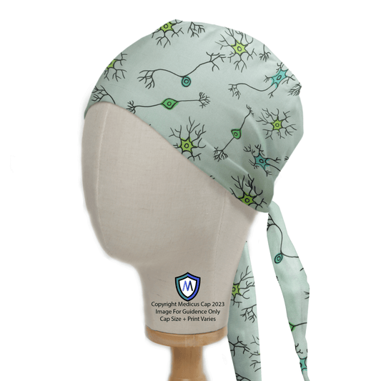 The mannequin head models a Medicus Scrub Caps Brain Neuron Network Scrub Cap in light green with black and green neuron patterns, showcasing a brain network design. It includes long side ties, with logo and copyright notice at the bottom.