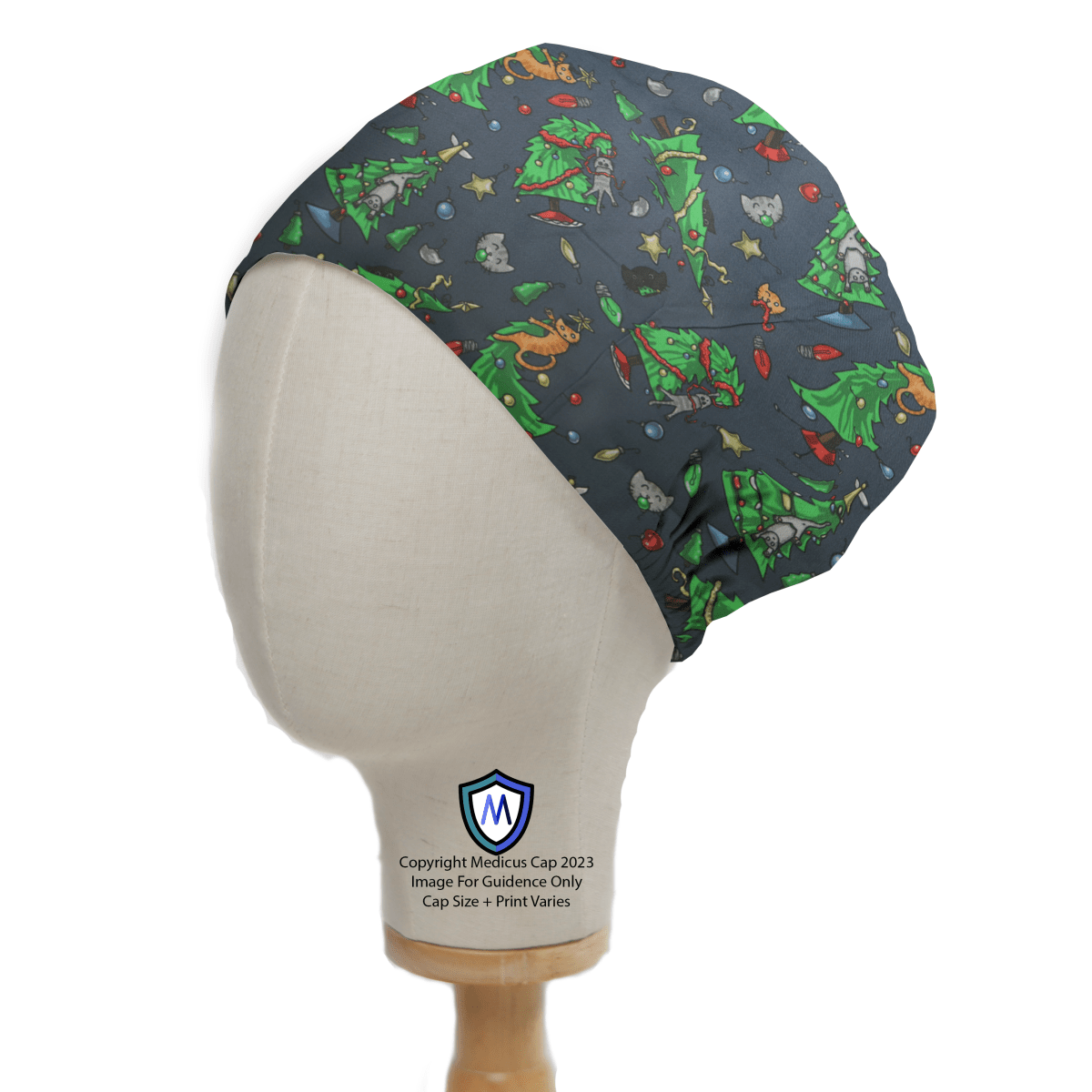 The mannequin head sports the Medicus Scrub Caps Christmas Cats Ruin Tree Scrub Cap, showcasing festive holiday designs like Christmas trees and mischievous cats. It features an elastic back, ideal for healthcare professionals, with a subtle logo at the base.