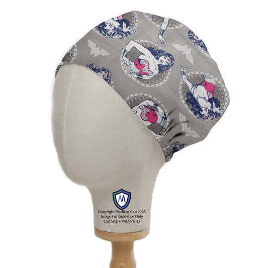 A mannequin head displays the DC Comic Wonder Woman Grey Circles Scrub Cap by Medicus Scrub Caps, featuring superheroine illustrations. The caps gray base is accented with red and blue, along with a logo and copyright text—ideal for medical professionals desiring stylish customization and empowerment.