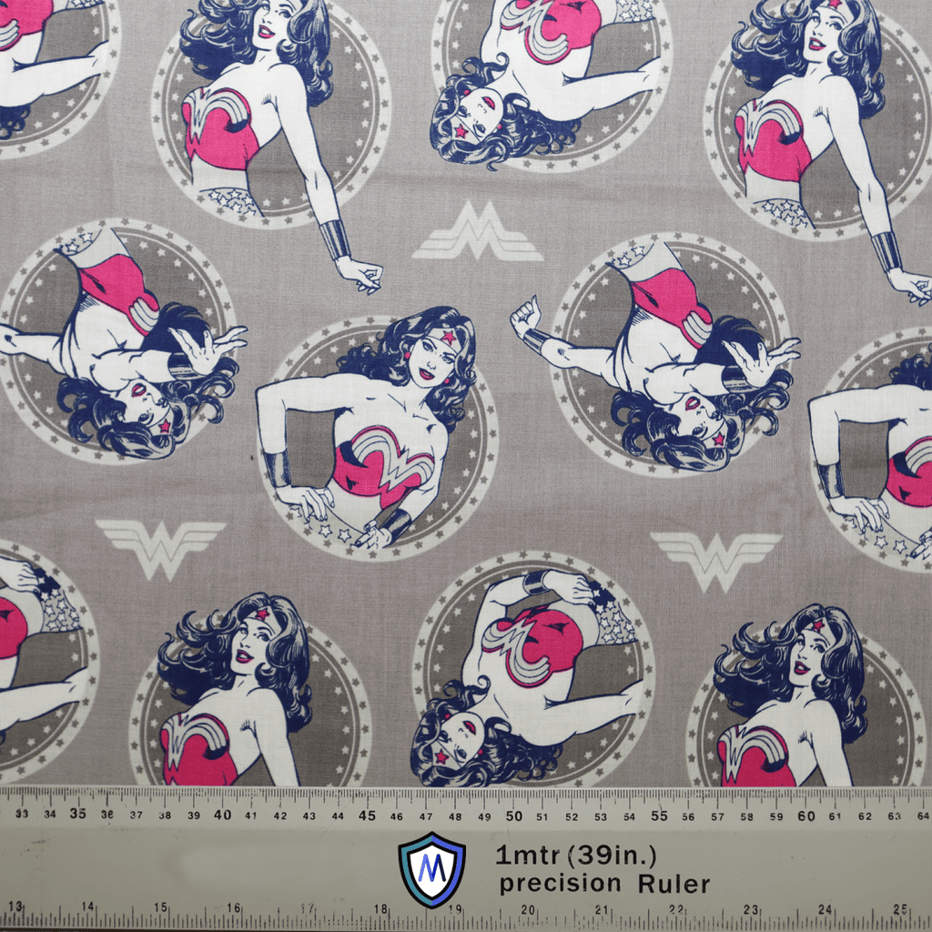 The Medicus Scrub Caps DC Comic Wonder Woman Grey Circles features a superheroine with long hair and a starred headpiece striking poses in circular frames. A 1-meter ruler at the bottom is ideal for designing your customizable scrub cap.