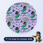 Defying Gravidity scrub cap print: a flying witch in green with operating tables, masks and syringes on lilac, with a Pre Order For October 2026 badge