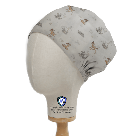 A Medicus Scrub Caps mannequin head showcases the Disney Bambi Small On Ice With Thumper scrub cap in light grey, adorned with cartoon deer and rabbits, and featuring a small blue and white shield logo, providing stylish comfort for healthcare attire.