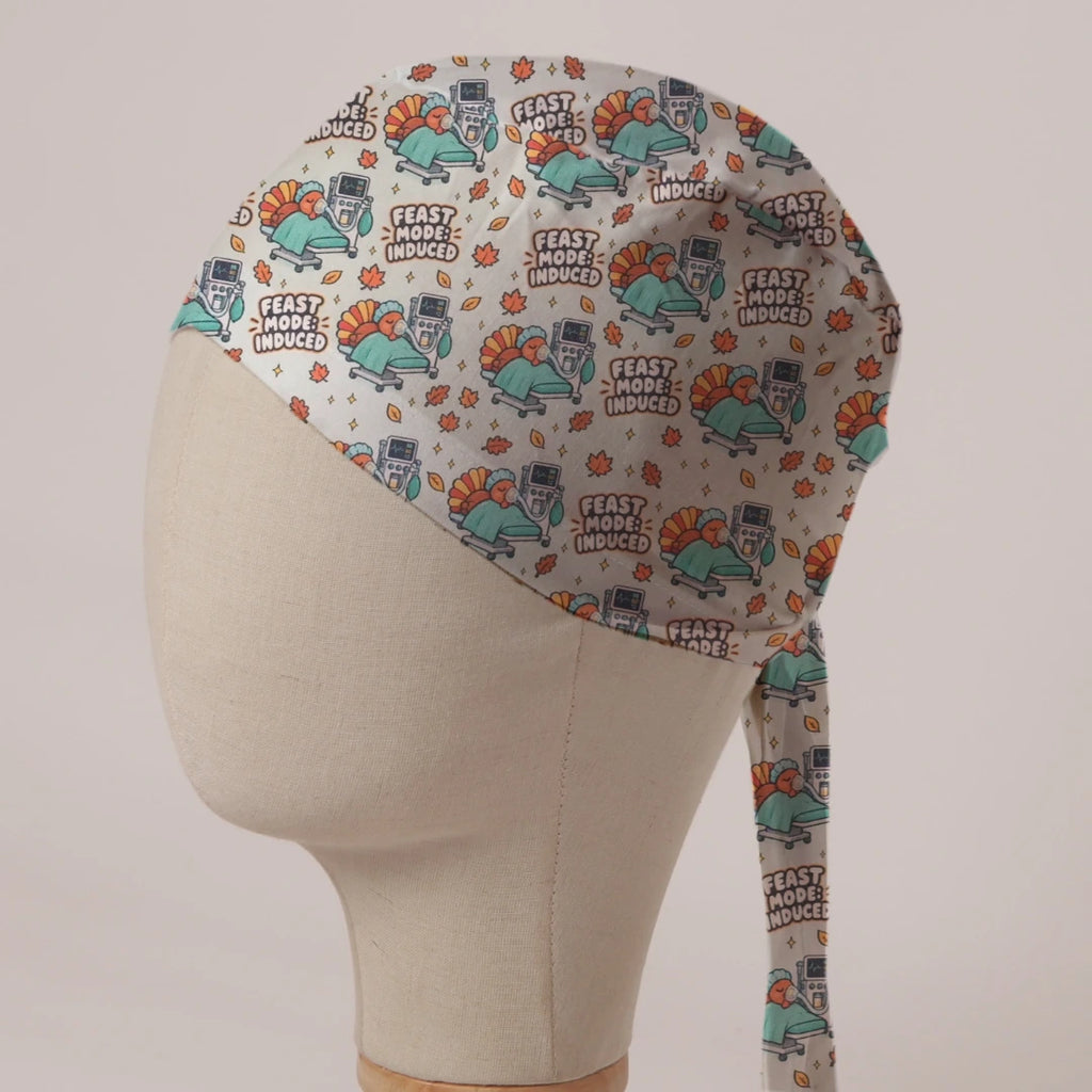 Feast Mode Induced scrub cap: turkeys on theatre trolleys beside anaesthetic machines with autumn leaves on cream