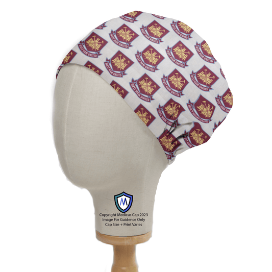 A Medicus Scrub Caps mannequin head displays the Football Club West Ham United Scrub Cap, featuring crests and UNITED in gold and maroon. Perfect for healthcare professionals, the cap is brimless and elegantly sits on a wooden stand, adding team spirit to any medical setting.