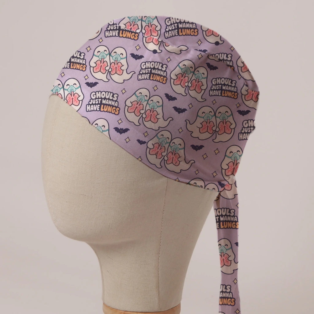 Ghouls Just Wanna Have Lungs scrub cap: ghosts in oxygen masks holding pink lungs with bats on lilac