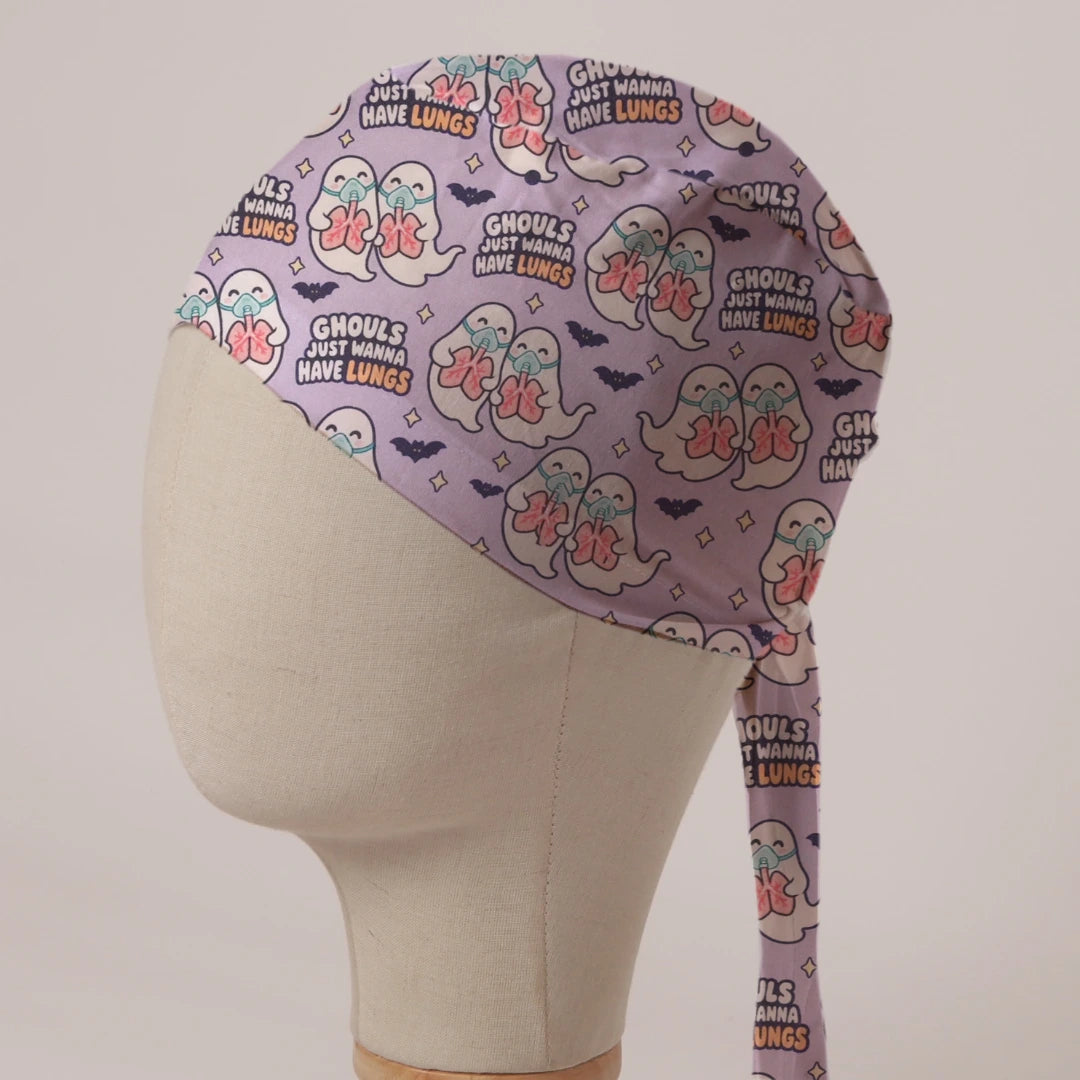 Ghouls Just Wanna Have Lungs scrub cap: ghosts in oxygen masks holding pink lungs with bats on lilac