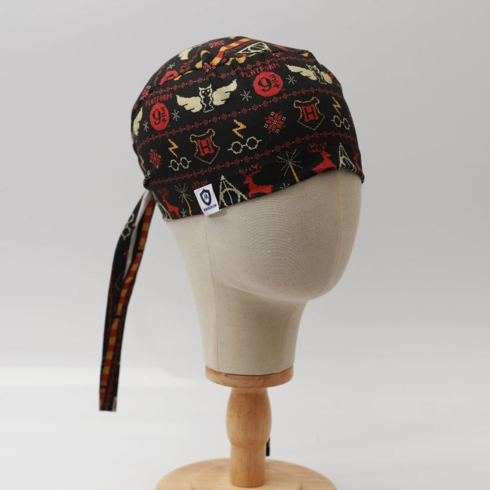 Mannequin head wearing Medicus Scrub Cap with Harry Potter Christmas jumper print, on a wooden stand against a white backdrop.