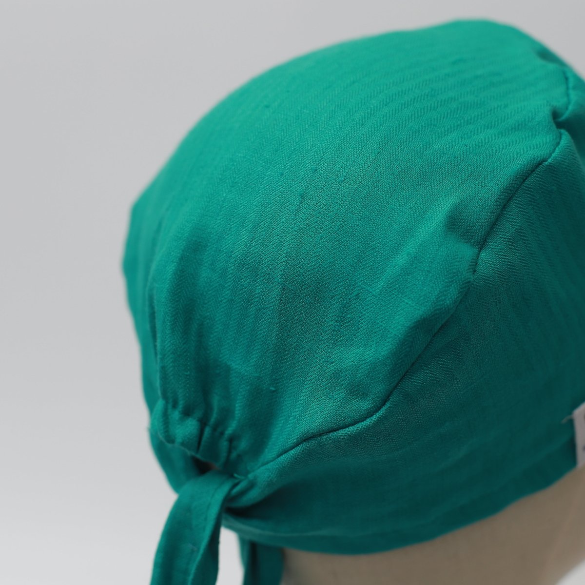 The Medicus Scrub Caps 100% Hemp Fabric Reusable Scrub Cap in Teal Green, tied at the back, displayed on a mannequin against a light background.