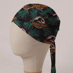 Jurassic Park Logo Jungle fabric scrub cap in Bandana tie-back style: Jurassic Park logo among palm leaves on black