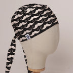 Moustaches On Black scrub cap in Bandana tie-back style on mannequin head, front right view with the Medicus label