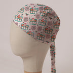 O Come All Ye Theatre Staff scrub cap: theatre staff in Santa hats singing carols from theatre lists with holly on pale grey