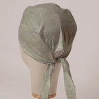 OBGYN on Misty Green scrub cap in Bandana tie-back style on mannequin head, back view with ties