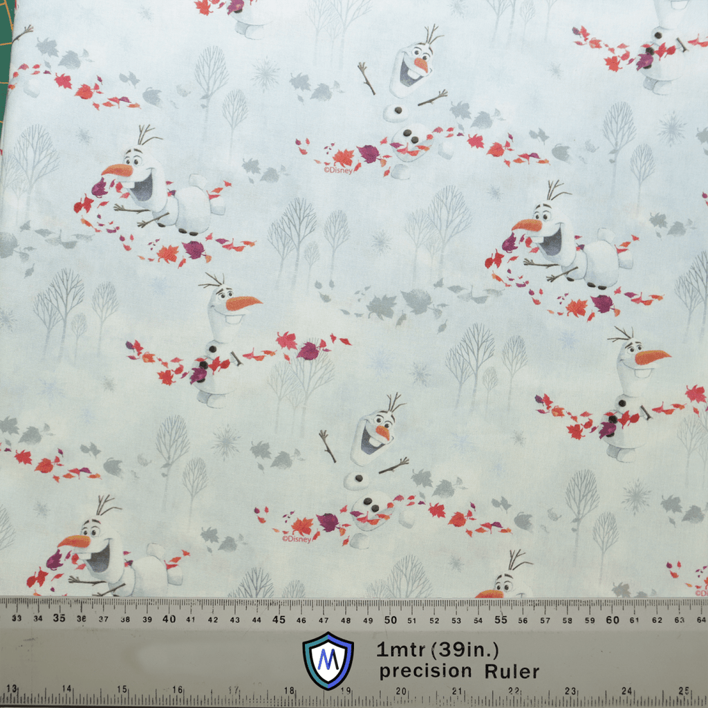 This Olaf Frozen Scrub Cap by Medicus Scrub Caps features patterned fabric with cartoon snowmen with orange noses and twig arms holding autumn leaves. The light blue background includes tree outlines, and a ruler at the bottom highlights the delightful details.
