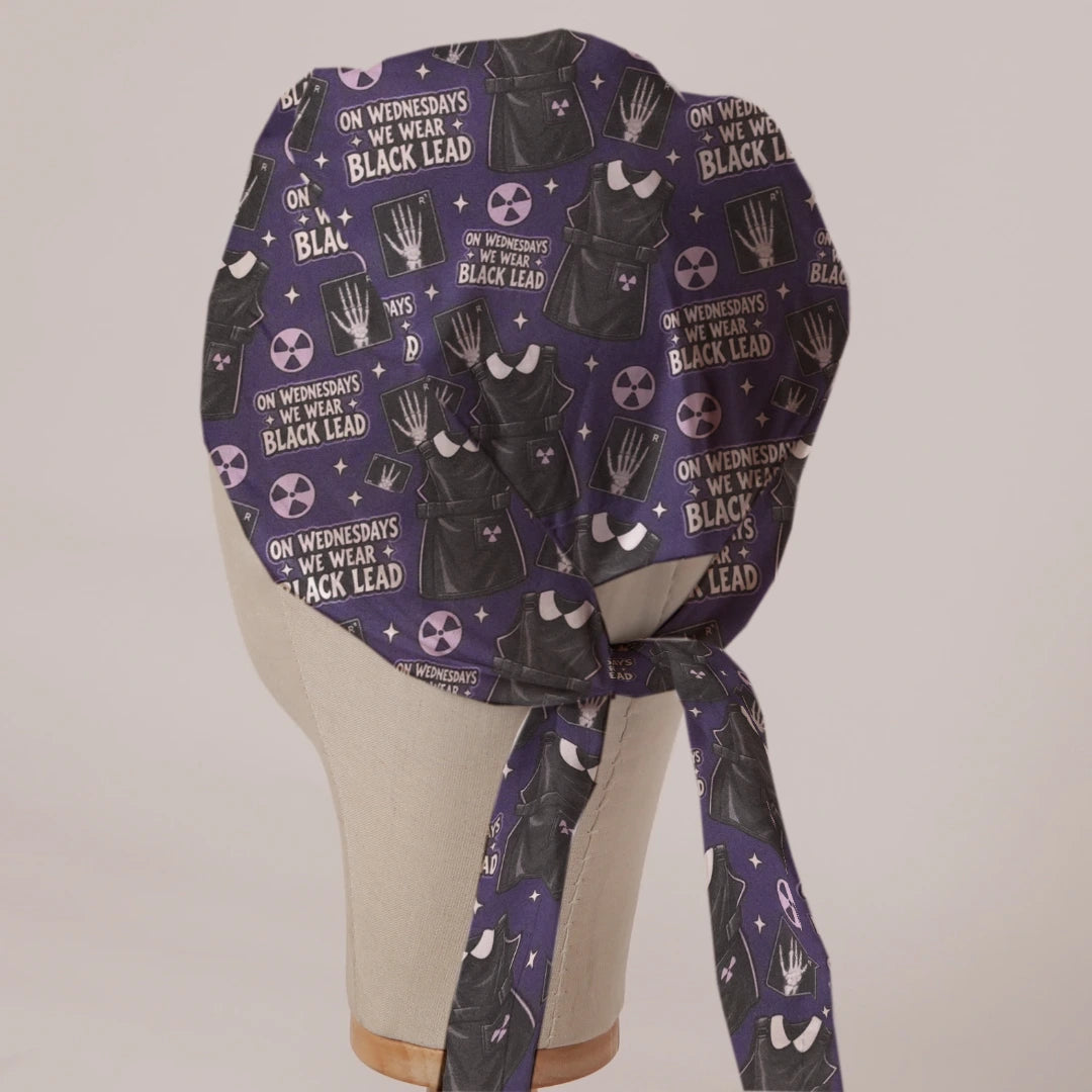 On Wednesdays We Wear Black Lead scrub cap in Bandana tie-back style on mannequin head, back view with ties