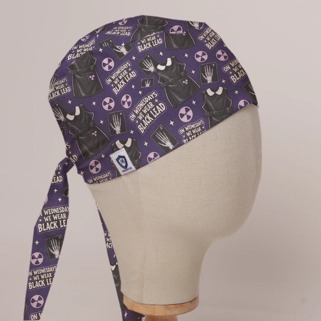 On Wednesdays We Wear Black Lead scrub cap in Bandana tie-back style on mannequin head, front right view with the Medicus