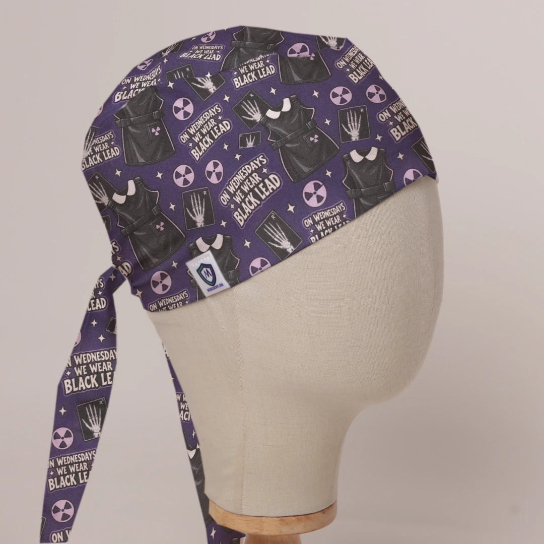 On Wednesdays We Wear Black Lead scrub cap in Bandana tie-back style on mannequin head, front right view with the Medicus