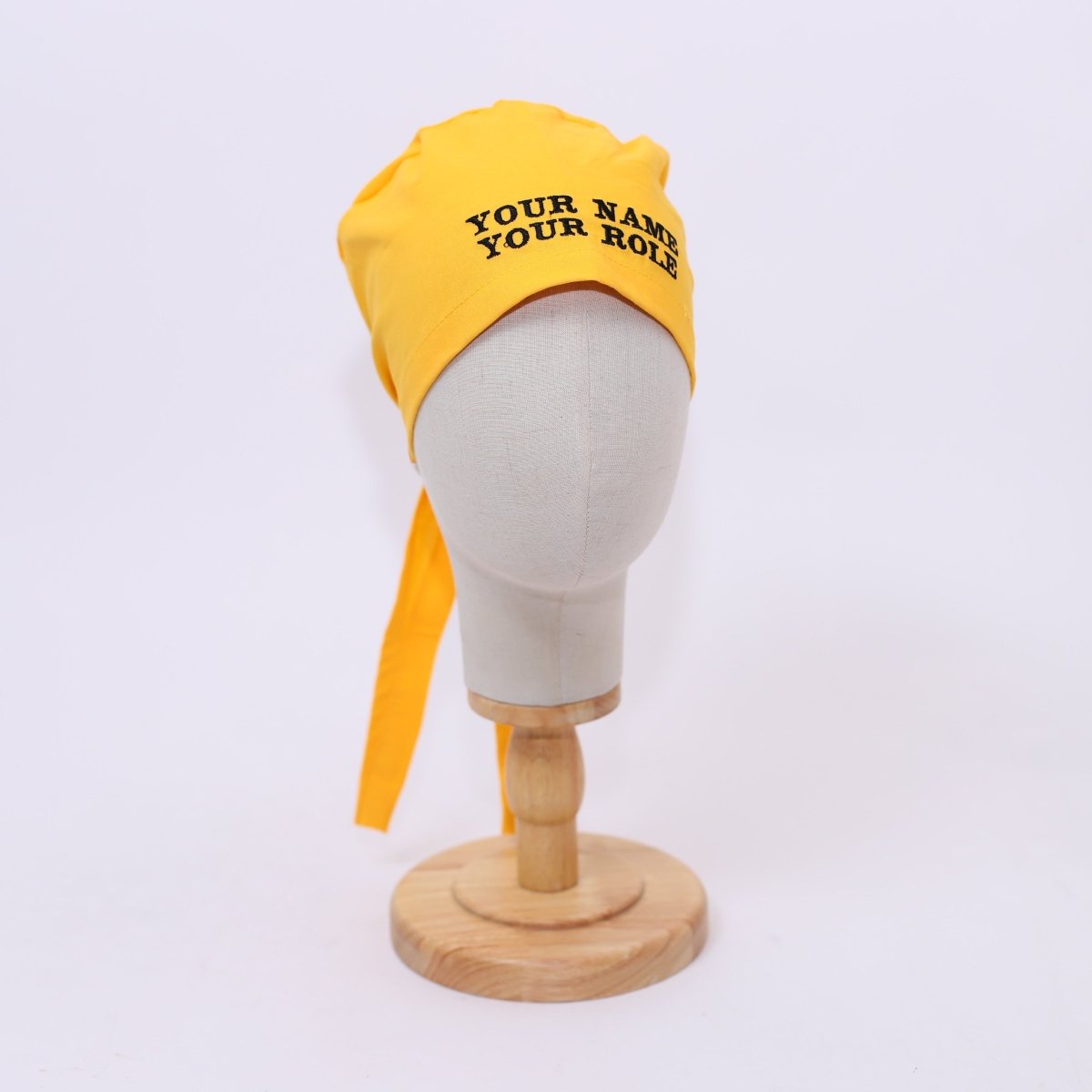 Yellow headscarf with text on a mannequin head against a white background