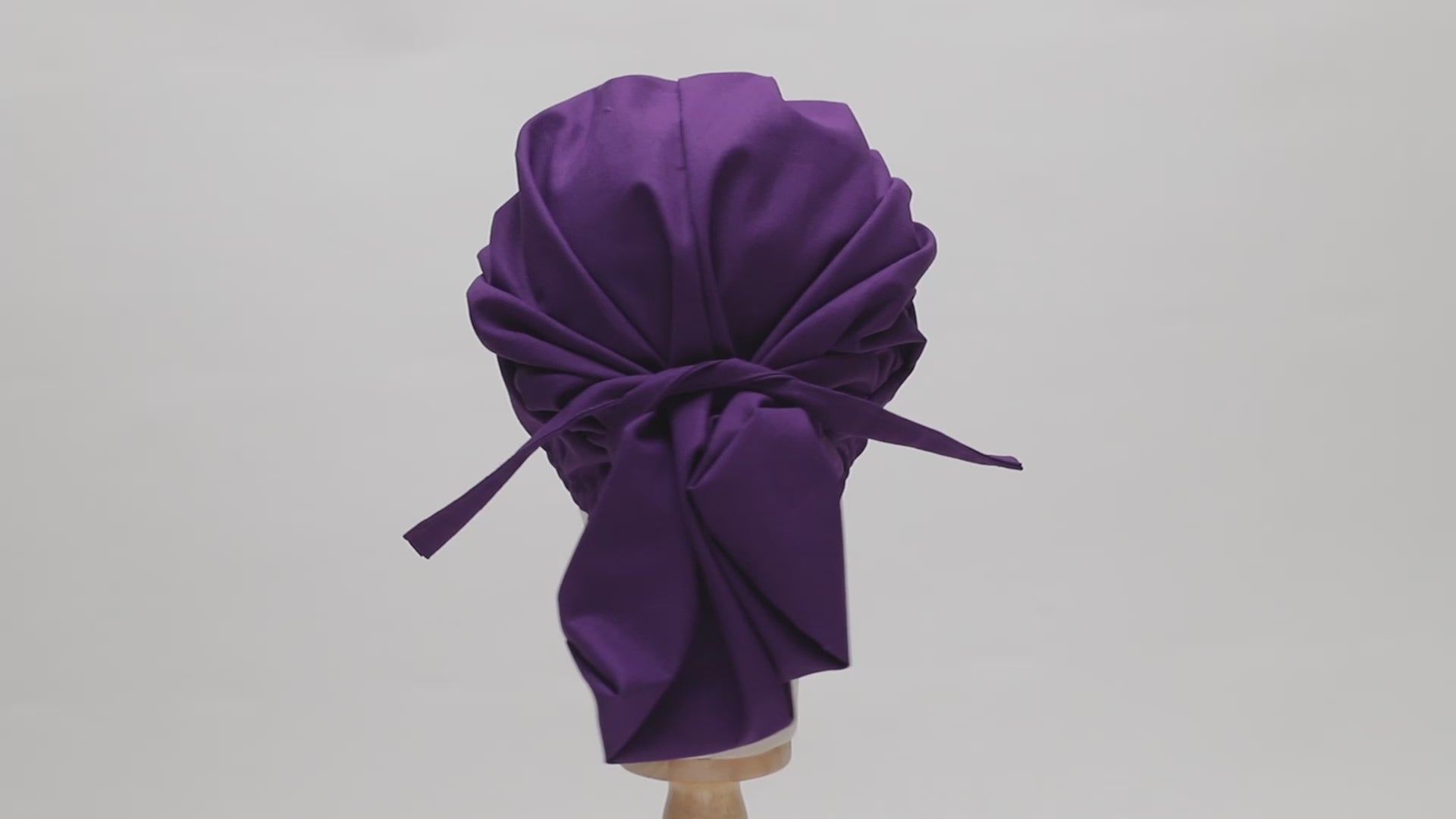 Video of a rotating purple scrub cap on a mannequin head, showing the back view.