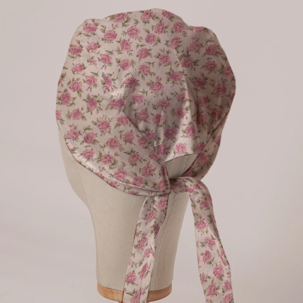 Small Roses On Beige scrub cap in Bandana tie-back style on mannequin head, back view with ties