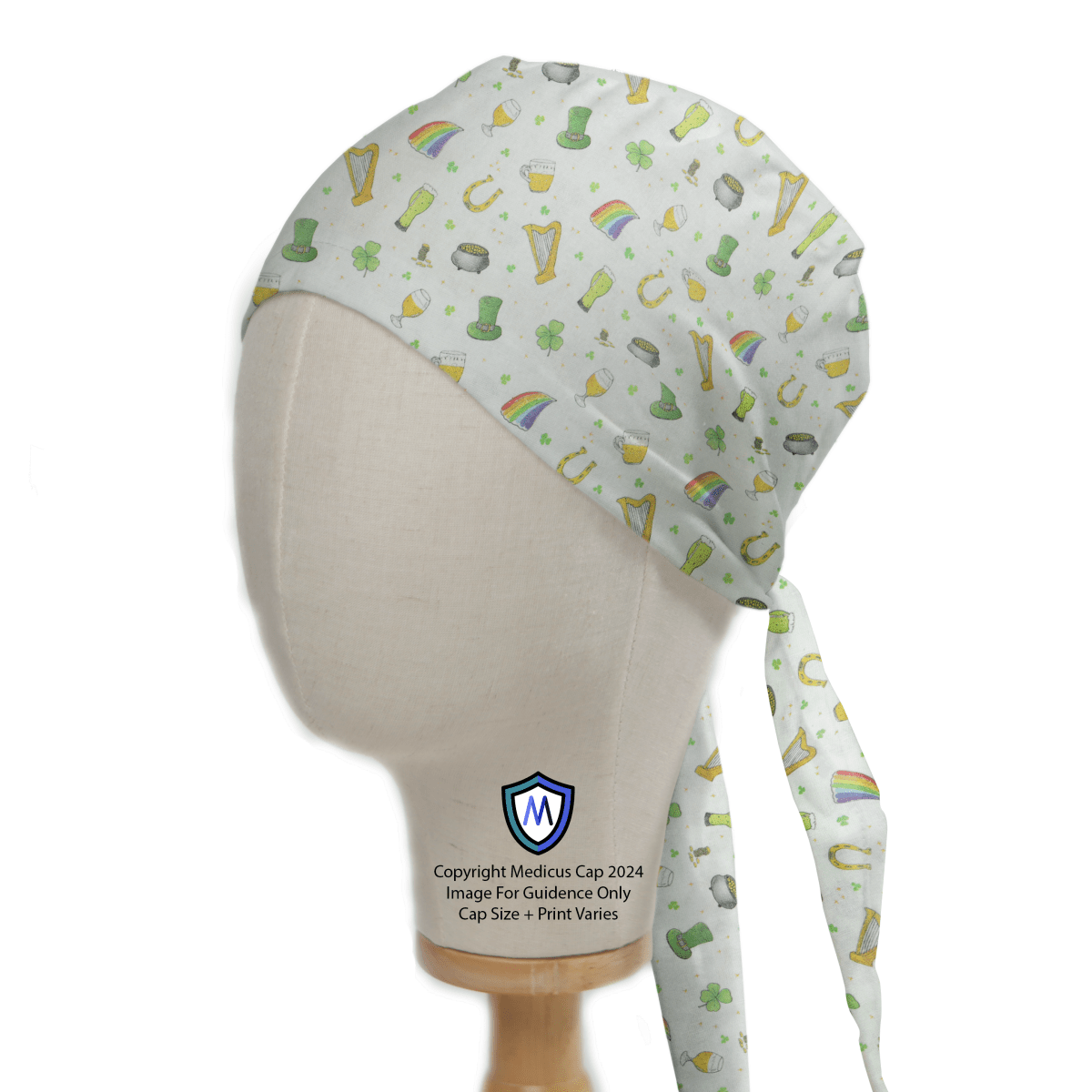 A mannequin displays the Medicus Scrub Caps St Patricks Day Trinkets Scrub Cap, featuring festive Irish-themed designs like rainbows, pots of gold, shamrocks, and leprechaun hats on crisp white fabric.
