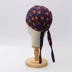 Back view of Superman logo scrub cap on navy background with tie strings visible