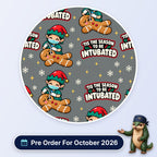 Tis The Season To Be Intubated scrub cap print: an elf anaesthetist intubating a gingerbread man with snowflakes on grey, with a Pre Order For October 2026 badge