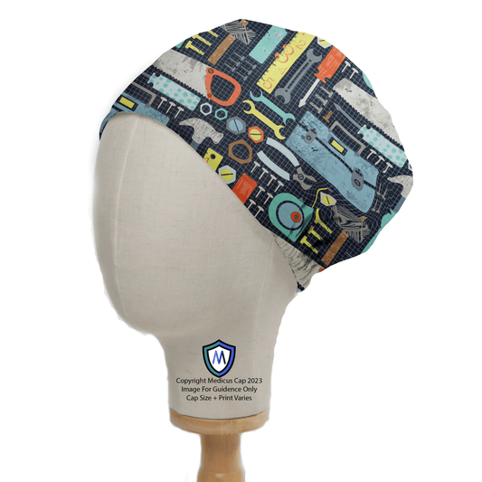 A Medicus Scrub Caps mannequin head displays the Tools Box Saw Hammer Large Scrub Cap. This sustainable headwear features a lively pattern of saws, wrenches, and hammers on a dark backdrop, blending playfulness with an industrious theme.