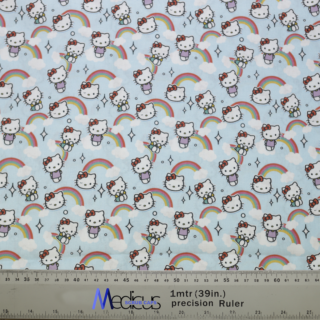 The Medicus Scrub Caps Hello Kitty Scrub Cap features a light blue fabric with Hello Kitty, rainbows, clouds, and stars, alongside a precision ruler for sizing.