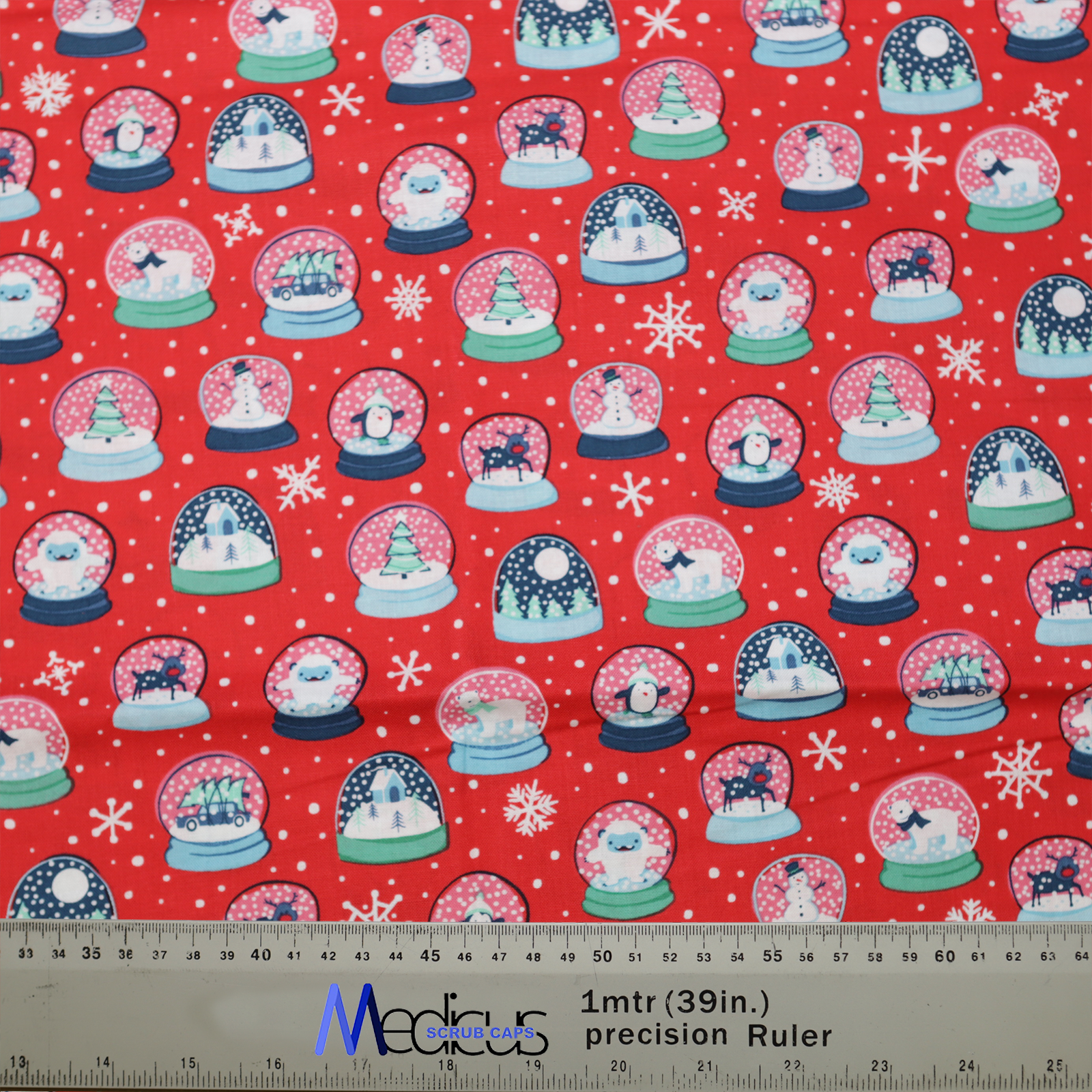 The Christmas Snow Globes Red Scrub Cap by Medicus Scrub Caps features festive snow globes and snowflakes on red fabric, with a scale ruler at the bottom.