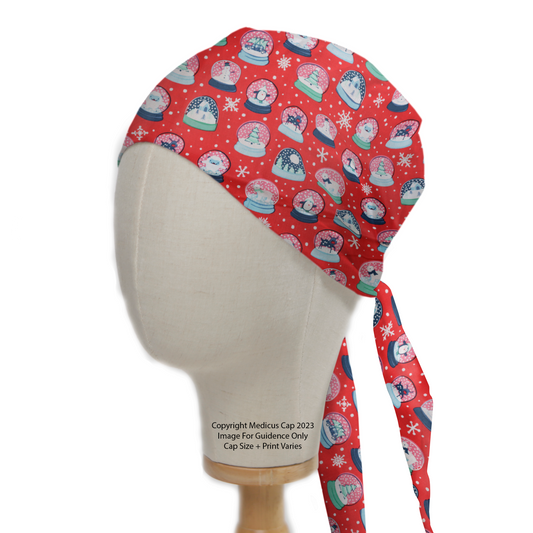 Festive Medicus Scrub Caps Christmas Snow Globes Red Scrub Cap on a mannequin, featuring snowmen and snowflakes in snow globes. Tie-back design for comfort.