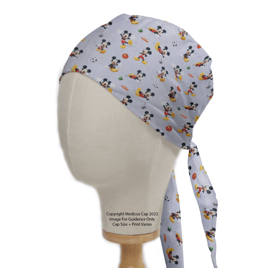 A mannequin head displays a Disney Mickey Football Frisbee scrub cap by Medicus Scrub Caps, featuring Mickey Mouse with sports-themed designs. Ties hang at the back.
