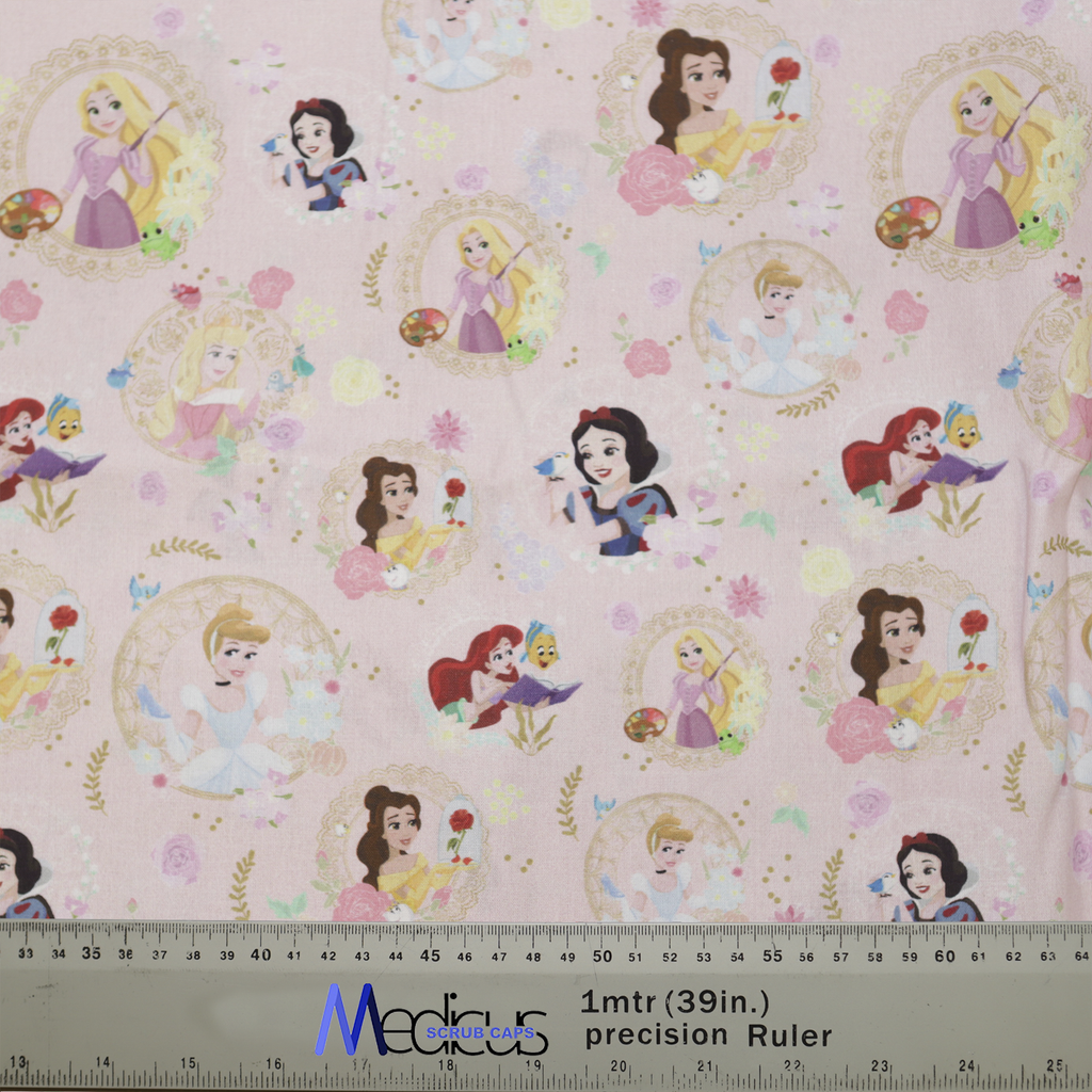 The Disney Princesses Mashup Pink Scrub Cap by Medicus Scrub Caps features a pink background with princess illustrations, flowers, and stars. Includes a precision ruler.