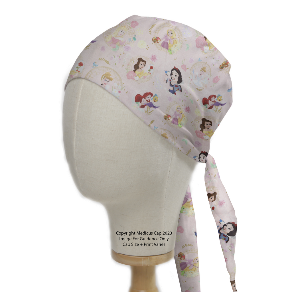 A Medicus Scrub Caps mannequin head displays the Disney Princesses Mashup Pink Scrub Cap, featuring a pink background with Disney Princesses and floral accents, tied elegantly.