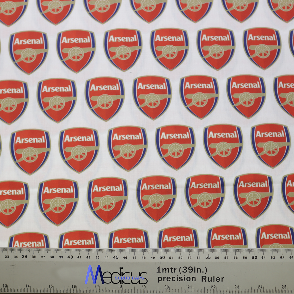 The Arsenal Scrub Cap by Medicus Scrub Caps features red and white fabric with repeating Arsenal logos and a precision ruler for accurate crafting.