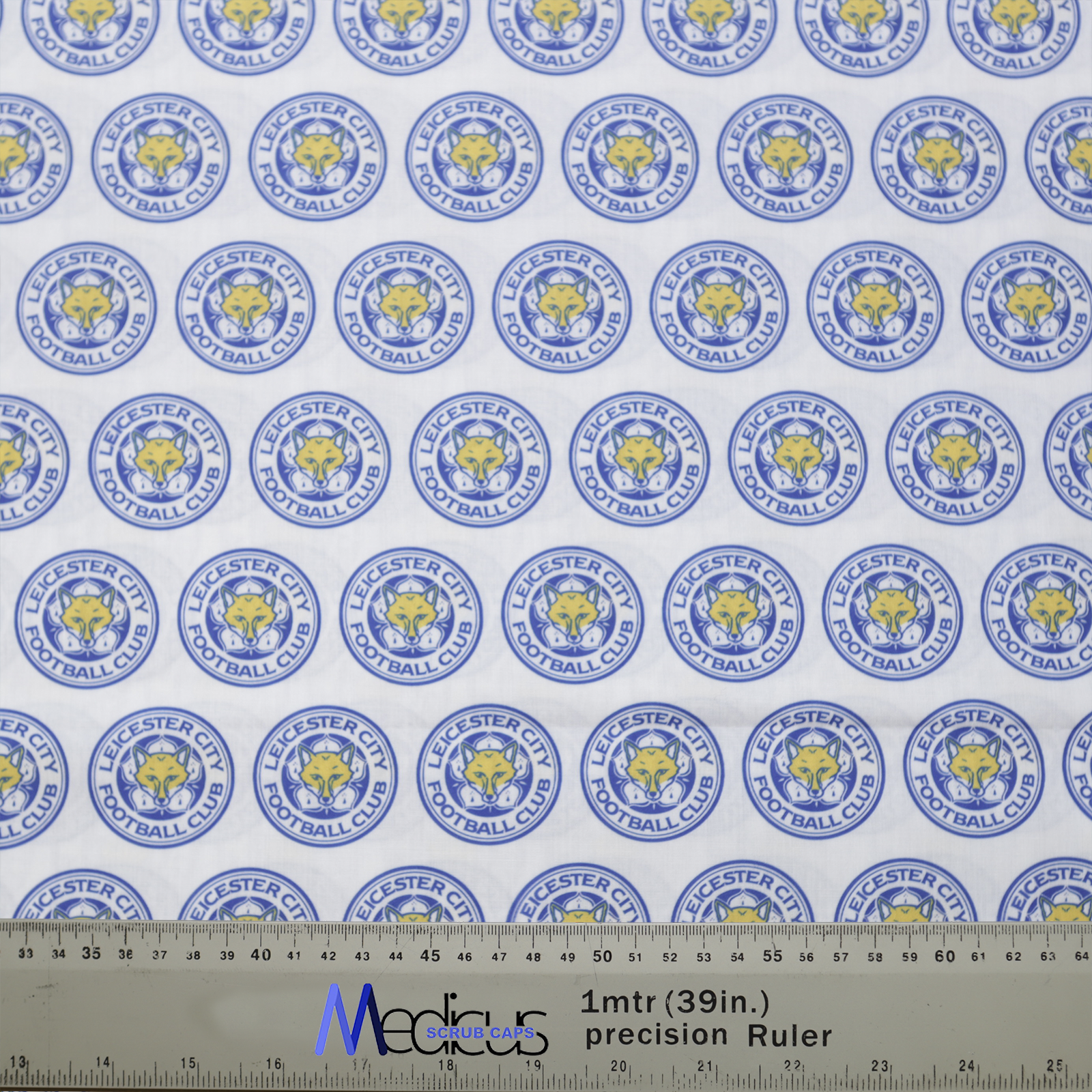 The Football Club Leicester Scrub Cap by Medicus Scrub Caps features a repeating Leicester City logo pattern in blue and yellow, perfect for sports-loving healthcare professionals.