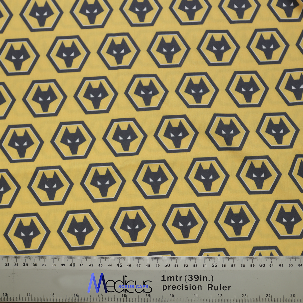 Yellow fabric with black hexagonal wolf head patterns, measured with a ruler. Perfect for custom Medicus Scrub Caps, inspired by Football Club Wolverhampton.