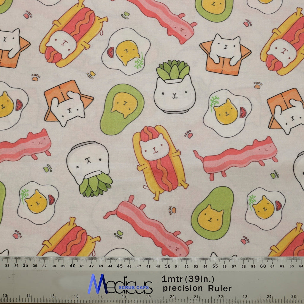 The Medicus Scrub Caps Funny Cat Food design features adorable cartoon cats as sushi, bacon, eggs, and avocados on a light background, with a fabric ruler.