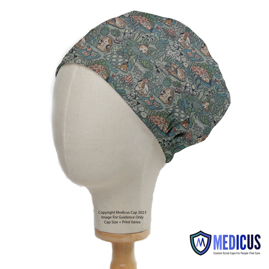 A mannequin head displays a Guinea Pig Wildlife Scrub Cap by Medicus Scrub Caps, featuring a jungle-themed design with guinea pigs and foliage.