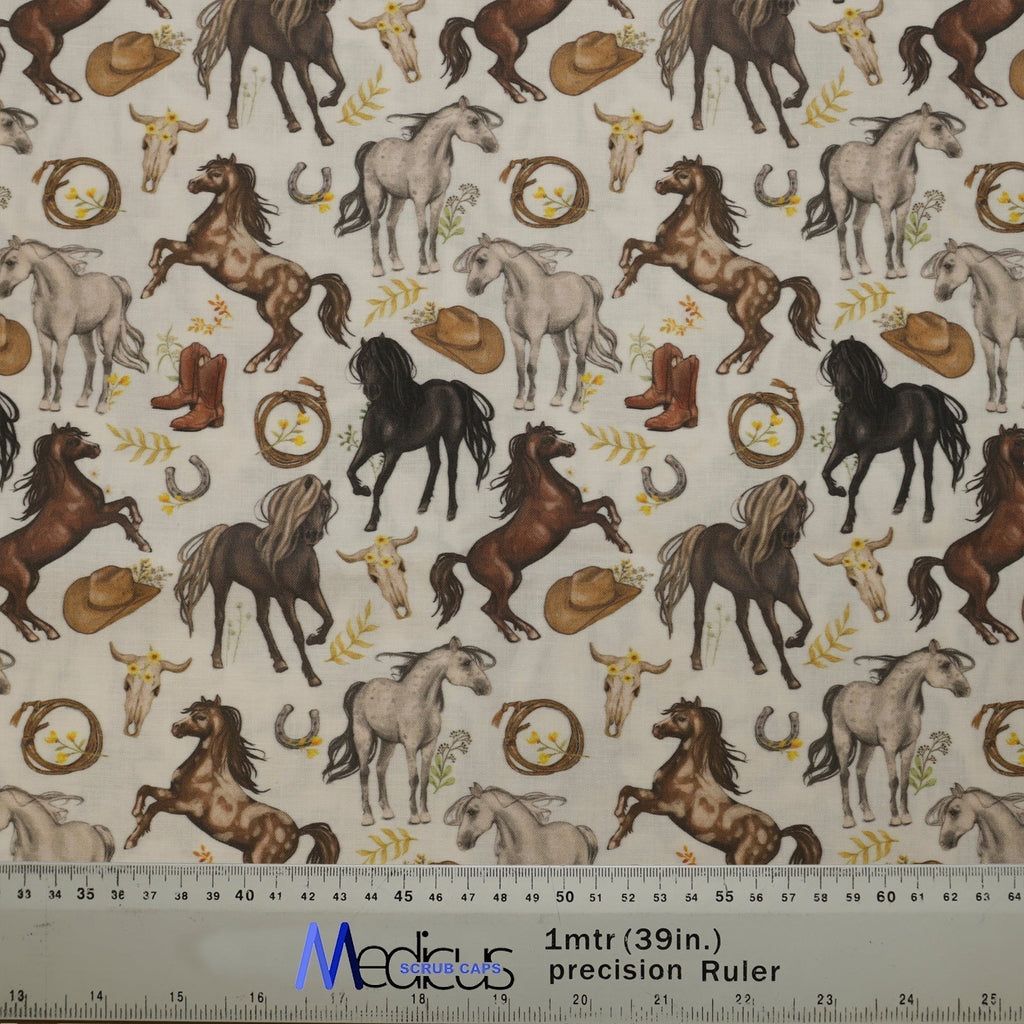 The Horses Run Wild With Accessories Scrub Cap by Medicus Scrub Caps features horses, cowboy hats, boots, horseshoes, and cow skulls. A ruler is visible for scale.