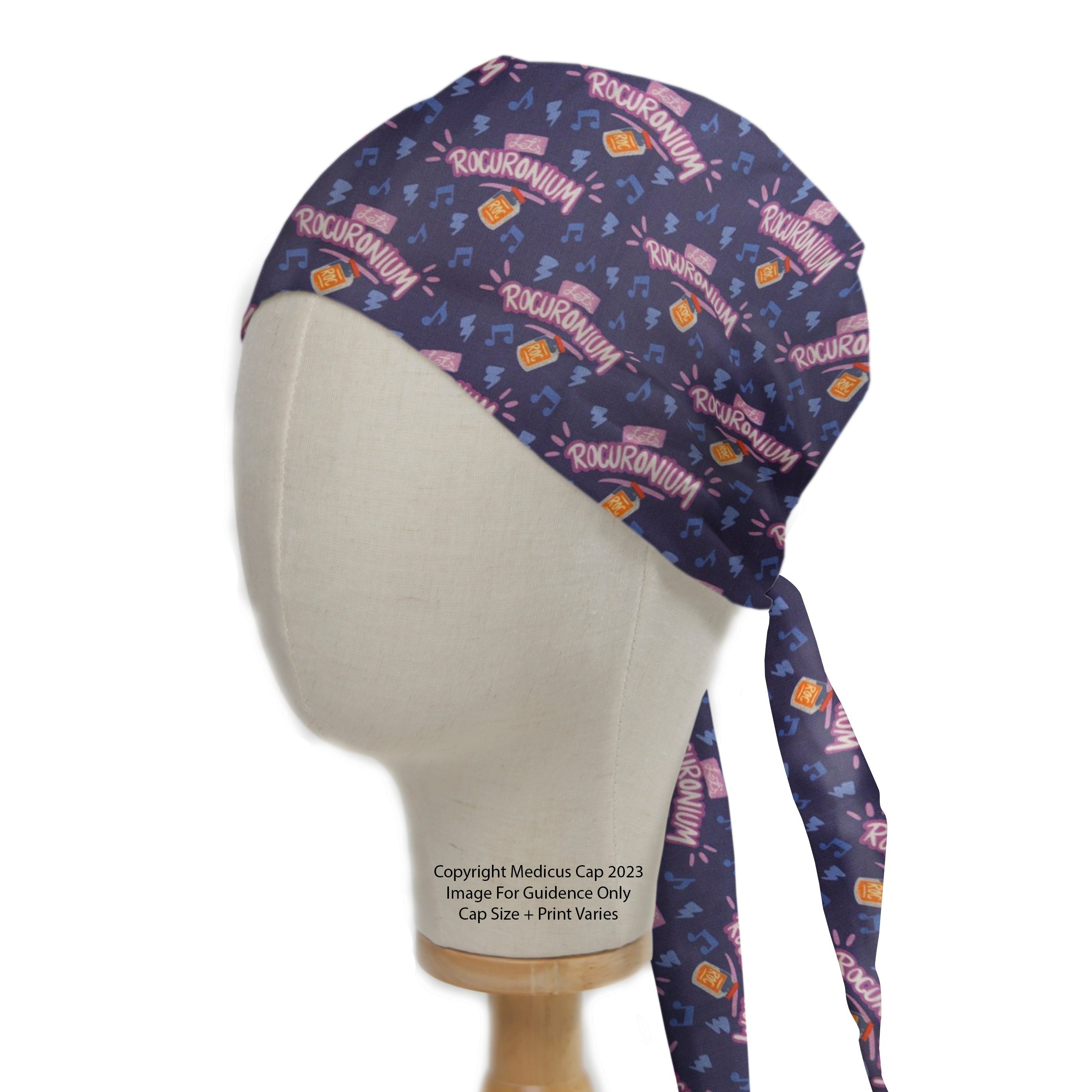 A mannequin displays the Lets Rocuronium Scrub Cap by Medicus Scrub Caps, featuring a purple design with musical notes and Rocuronium prints, tied at the back. © Medicus Cap 2023.