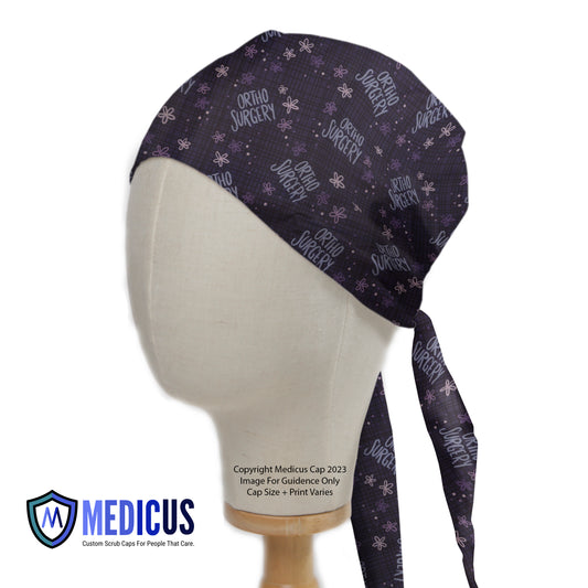 Ortho Surgery Scrub Cap from Medicus Scrub Caps, featuring a dark patterned design with "Ortho Surgery" text and floral accents.