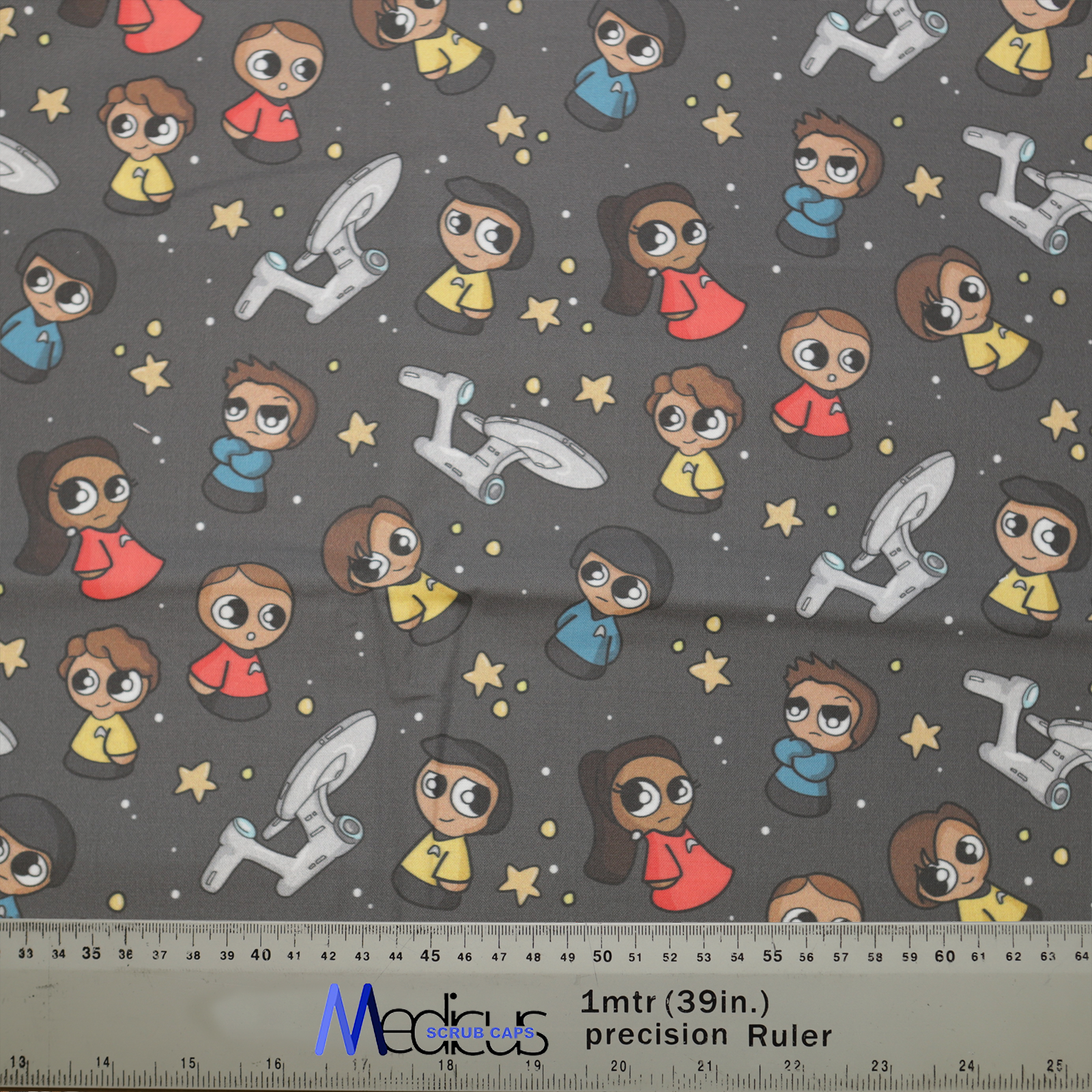 The Medicus Scrub Caps Space Cartoon Star Trek Kawaii Scrub Cap features cute space explorers, starships, and stars on a dark background, with a ruler for scale.